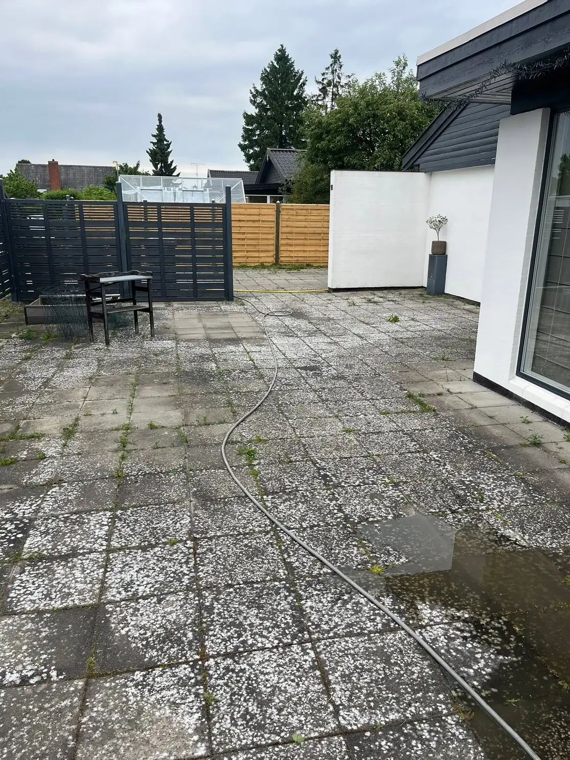 Grå fliser ved hus før fliserens